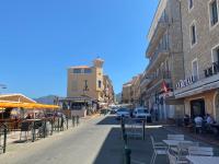 a city street with tables and chairs and buildings at Duplex en plein centre in Propriano