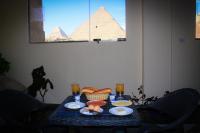 a table with food on it with the pyramids at Energy Of Pyramid Hotel in Cairo