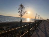 a fence on the beach with the sun setting at Casa Las Toro Playa in Chilches