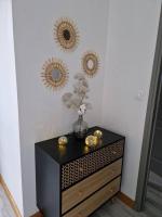 a black dresser with three mirrors on a wall at Chez Aurélie et Bruno in Montceau-les-Mines