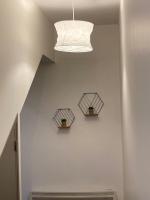 a white wall with two windows and a light fixture at Chez Aurélie et Bruno in Montceau-les-Mines