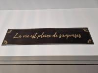 a black sign with gold writing on a wall at Chez Aurélie et Bruno in Montceau-les-Mines