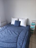 ein Bett mit einer blauen Decke und zwei Kissen in der Unterkunft Studio 2 Personnes -- Vue Port de Comberge ! in Saint-Michel-Chef-Chef