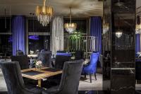 a dining room with a table and blue chairs at Hotel Cristal Park in Tarnów