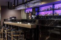 a bar with stools in a room with purple lighting at Hotel Cristal Park in Tarnów