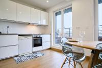 une cuisine avec des placards blancs et une table en bois dans l&#39;établissement 3 bedroom apartment with balcony, à Marcq-en-Barœul