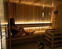 a woman is sitting in a sauna at Atypik Hotel in Clichy