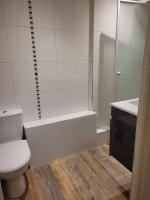 La salle de bains blanche est pourvue d&#39;une douche et de toilettes. dans l&#39;établissement Appartement 2 chambres 1 salle de bain Paris 8eme Champs Elysées, à Paris