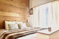 a bedroom with a bed with a wooden wall at Family cocoon Prime Rochebrune location in Megève