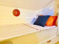 a bed with orange and blue pillows on a boat at Family cocoon Prime Rochebrune location in Megève
