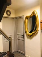 a gold mirror on the wall next to a door at Family cocoon Prime Rochebrune location in Megève