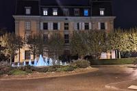 a building with a fountain in front of it at night at Appartement avec vue 180 sur le Lac Léman in Thonon-les-Bains