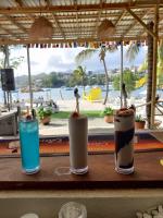 Tres cócteles en una mesa con vistas a la playa. en Blue Lagoon Hotel and Marina Ltd, en Kingstown