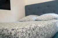 ein Bett mit einer schwarzen und weißen Bettdecke und 2 Kissen in der Unterkunft Studio Douillet à Neuilly-sur-Marne in Neuilly-sur-Marne