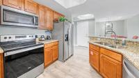 eine Küche mit Holzschränken und einem Edelstahlkühlschrank in der Unterkunft St Lucia 1204 a Luxury Condo with Gulf Views in Destin