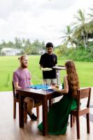 Dos hombres y una mujer sentados en una mesa con una pizza en Serene Park Hotel By Ark, en Tissamaharama