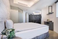 a bedroom with a large white bed and flowers at CHECK inn Taichung Liming in Taichung