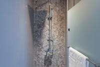 a shower in a bathroom with a tile wall at CHECK inn Taichung Liming in Taichung