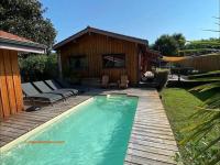 una piscina en un patio junto a una casa en Villa piscine privée 12 personnes, en Lacanau