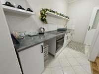 a white kitchen with a counter top and a stove at ModernA Hall One Bedroom in Sremska Mitrovica