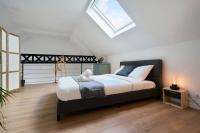 a bedroom with a large bed with a skylight at Loft en duplex atypique 4ch + parking in Tourcoing