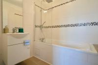 a white bathroom with a shower and a sink at Loft en duplex atypique 4ch + parking in Tourcoing