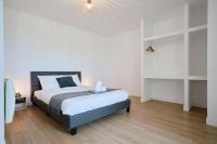 a bedroom with a bed with white walls and wooden floors at Loft en duplex atypique 4ch + parking in Tourcoing