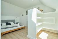 a white bedroom with a bed and stairs at Loft en duplex atypique 4ch + parking in Tourcoing