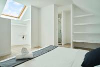 a bedroom with a white bed and a skylight at Loft en duplex atypique 4ch + parking in Tourcoing