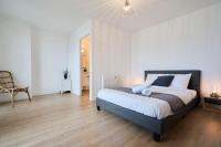 a bedroom with a large bed and a chair at Loft en duplex atypique 4ch + parking in Tourcoing