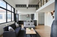 a living room with two couches and a table at Loft en duplex atypique 4ch + parking in Tourcoing