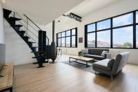 a living room with a couch and a staircase at Loft en duplex atypique 4ch + parking in Tourcoing