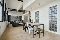 a dining room and living room with a table and chairs at Loft en duplex atypique 4ch + parking in Tourcoing
