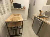 a small kitchen with a table and a sink at Maisonnette cocooning in Nogent-le-Rotrou