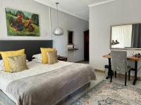 Un dormitorio con una cama, una mesa y un escritorio. en Rabbit Hole Hotel, en Krugersdorp