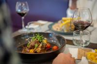 Una mesa con un plato de comida y una copa de vino. en Hotel-Restaurant Horizon Ath-Lessines, en Ghislenghien