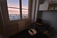 a room with a window and a table and a table and chairs at Appartement avec vue 180 sur le Lac Léman in Thonon-les-Bains