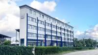 Un edificio blanco con ventanas azules en una calle. en Hotel Rhein-Ruhr Bottrop, en Bottrop