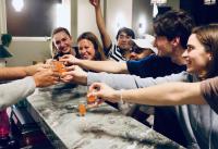a group of people gathering around a table with drinks at Gspot Hostels & Love Triangles Pizzeria in Lisbon