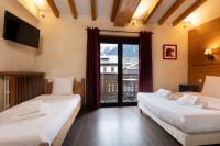 two beds in a room with a large window at Le Saint Antoine in Les Houches