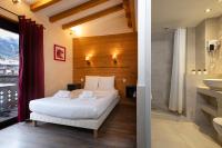 a bedroom with a white bed and a bathroom at Le Saint Antoine in Les Houches
