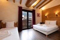 a bedroom with two beds and a window with a view at Le Saint Antoine in Les Houches