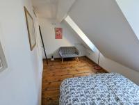 a attic bedroom with a bed and a chair at Appartement des Serruriers in Strasbourg