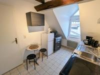 a kitchen with a small table and a refrigerator at Appartement des Serruriers in Strasbourg