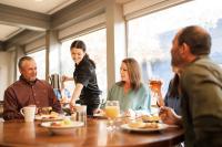 Un grupo de personas sentadas alrededor de una mesa en un restaurante. en Callaway Resort & Gardens, en Pine Mountain