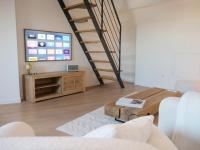 a living room with a tv and a staircase at Magnifique cocon in Amiens