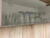 a shelf with glass jars and vases on it at Kula Dream apartment in Kula