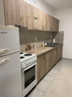 a kitchen with a stove and a white refrigerator at Kula Dream apartment in Kula