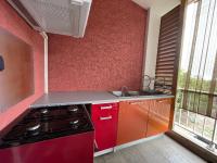 a red kitchen with a stove and a sink at CASA COLIVING avec chambre salle de bain individuelles privatives in Saint-Pierre