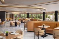 Un restaurante con mesas y sillas y un bar. en The St. Regis Jakarta, en Yakarta